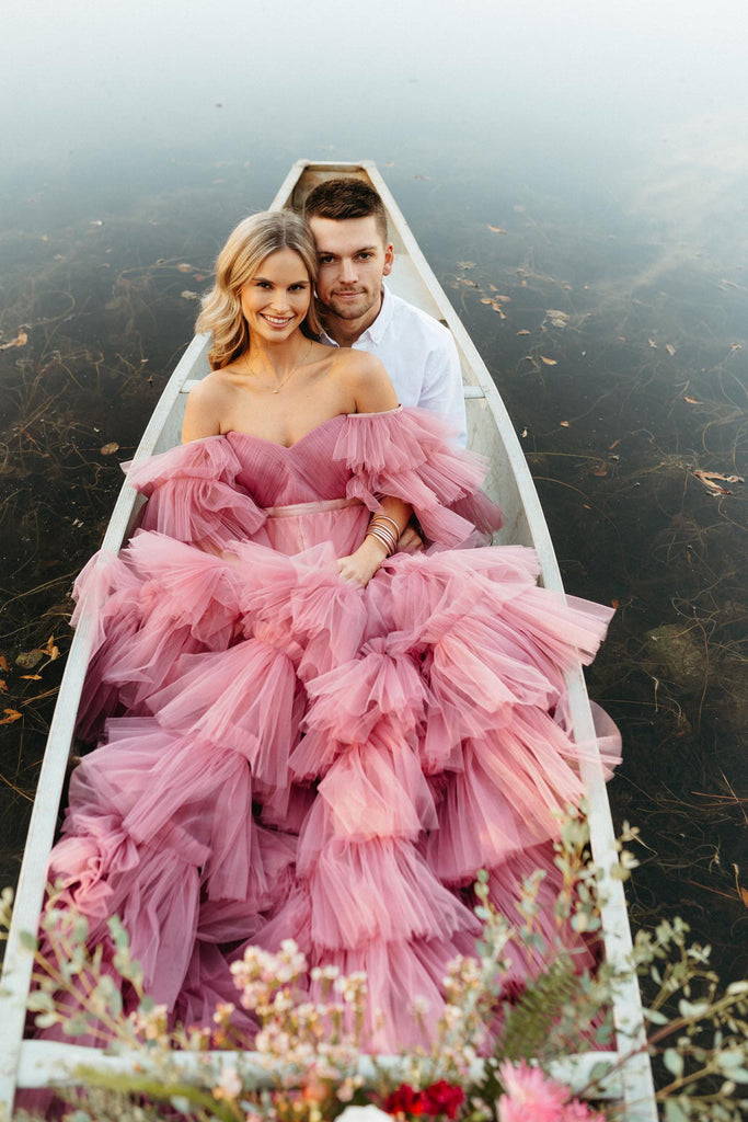 Couples photo shoot in pink tulle dress on in a boat on the lake salt gowns dresses